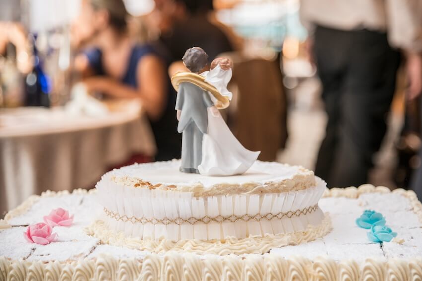 Wedding anniversary wishes for couple: bride and groom cake topper on a cake